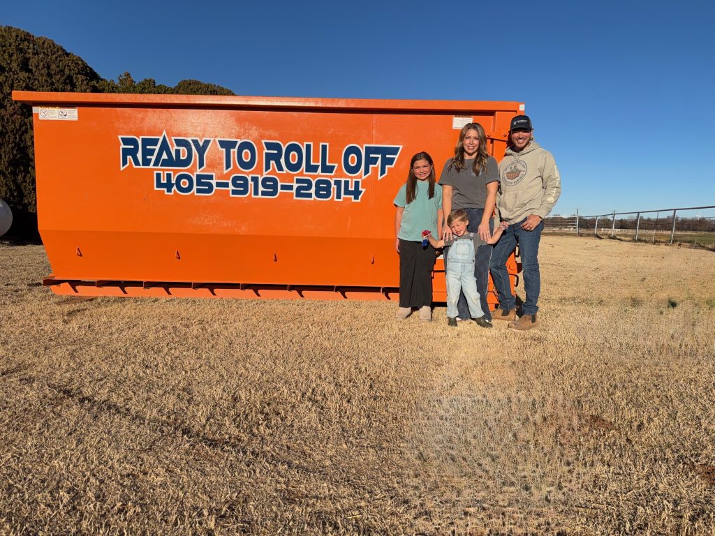 family photo of the Pinas in front of a roll off dumpster available for rent in Oklahoma City